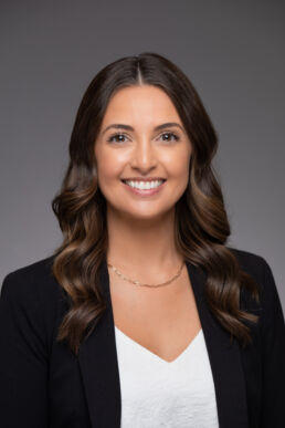 Corporate headshot of female executive against gray background shot with onsite studio in Clearwater, Fl.