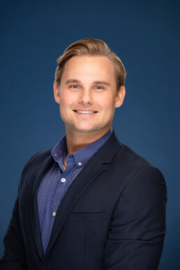Profile photo of male professional with blue background for company website in Clearwater, Florida.