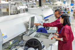 Employees in electrostatic uniforms monitor industrial computer component factory production in Tampa, Fl by Sarasota Industrial photographer Carver Mostardi.