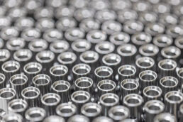 Rows of metallic bolts come down production line at industrial manufacturing facility in Orlando, Florida.